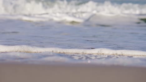 foam from breaking waves washed up on sandy sylt beach in germany