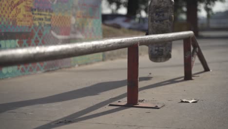 rallentatore primi piani di pattinatore skateboard e macinazione su rotaia all'aperto allo skate park durante la giornata di sole