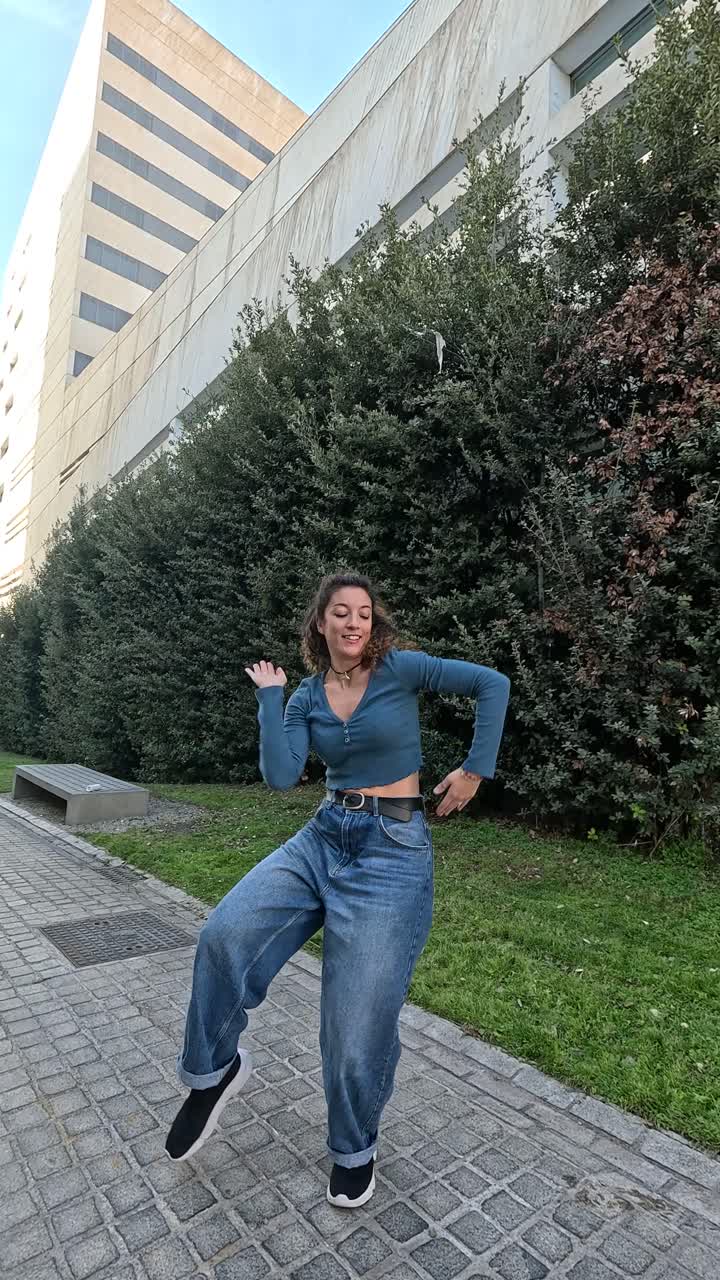 Young urban dancer performing outside modern building