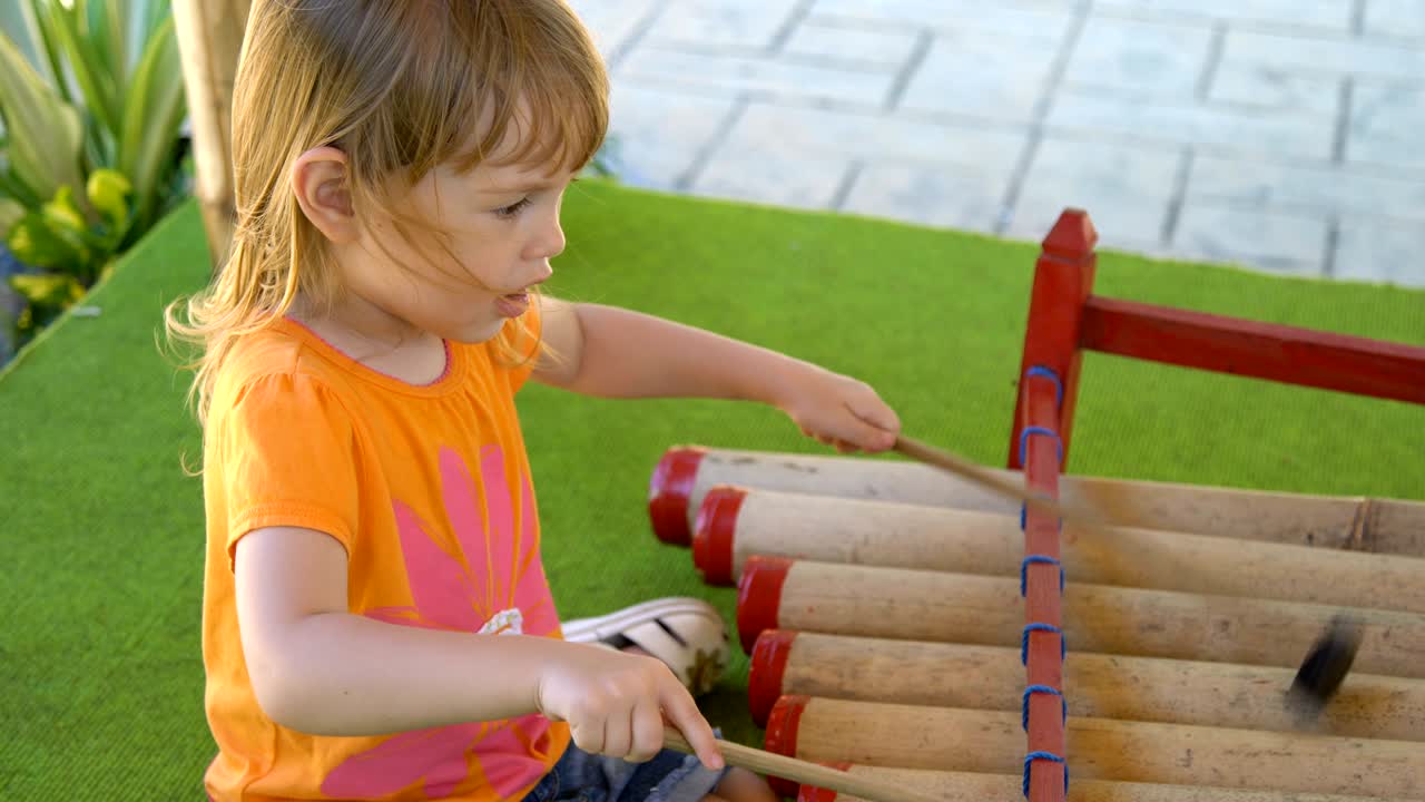 pequeña niña tocando instrumentos tradicionales indonesios