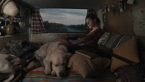 Woman-Working-on-Laptop-and-Petting-Dog-in-Cozy-Camper-Van