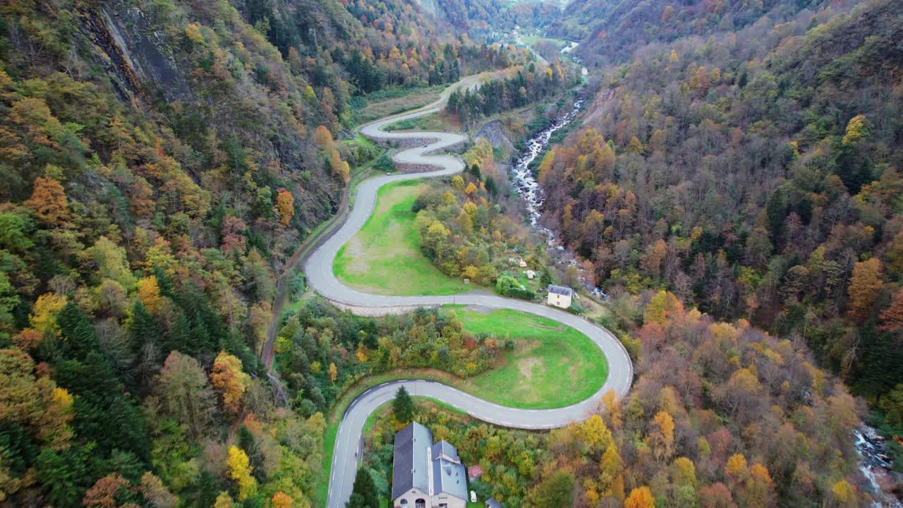 Winding road through vibrant autumn hills in French Pyrenees to Cauterets