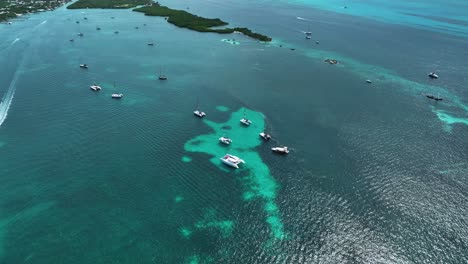 Luftaufnahme-über-Katamarane-In-Türkisfarbenem-Wasser,-Von-Isla-Mujeres,-Mexiko---Neigung,-Drohnenaufnahme