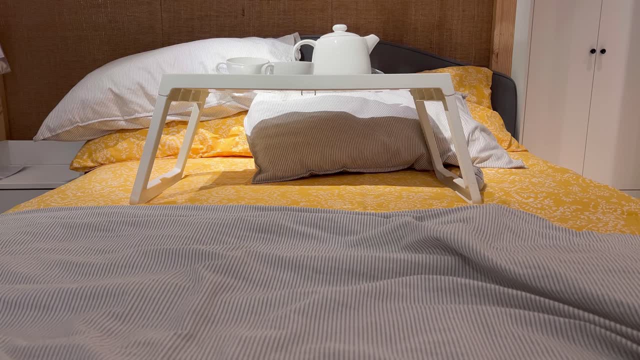 статичный снимок чая в белой чашке и чайнике, поставленных на маленький столик