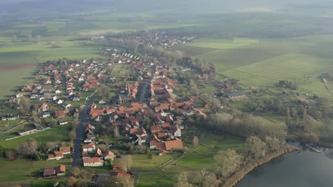 Drone-aerial-of-the-typical-german-village-Seeburg-located-at-the-Seeburger-See-on-a-beautiful-Sunday-morning