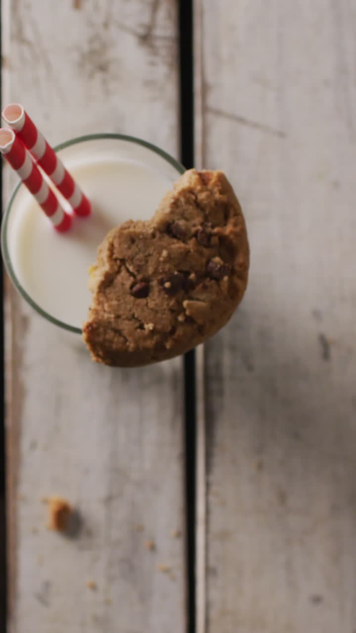 Video of glass of milk and cookie on wooden background