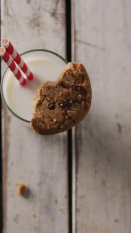 video de un vaso de leche y una galleta sobre un fondo de madera