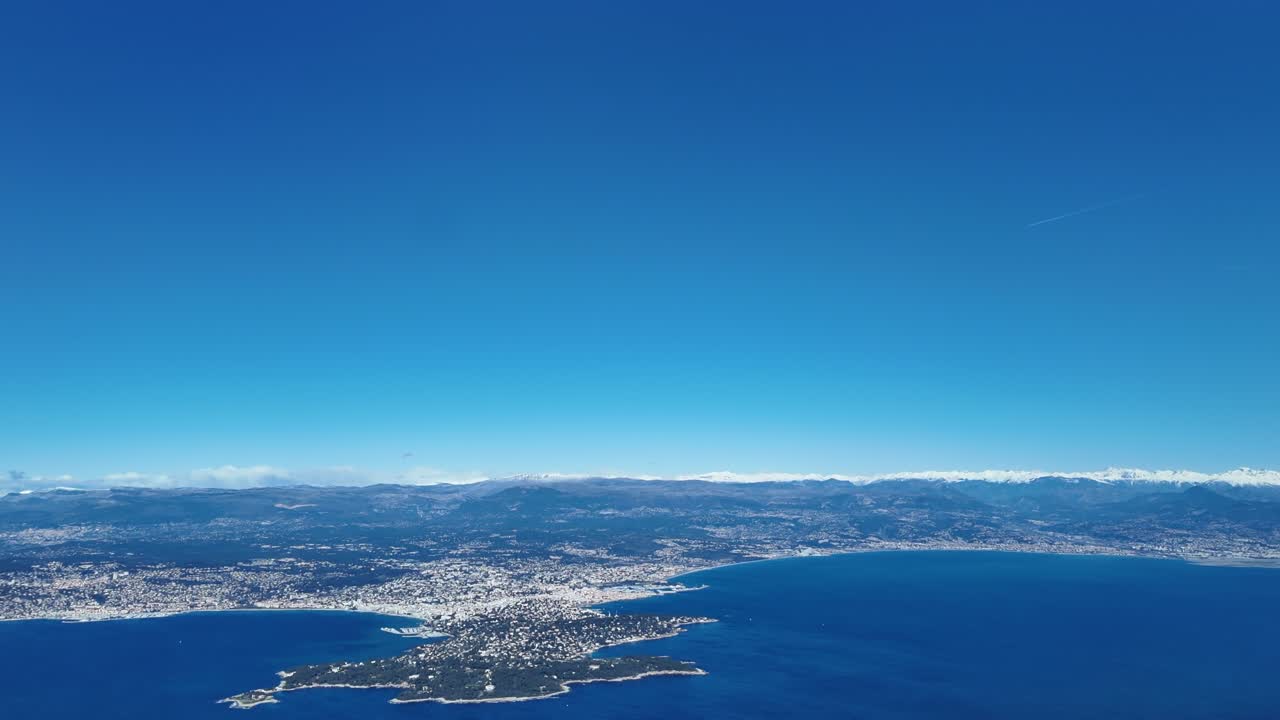 Pemandangan udara dari ketinggian Cap d'Antibes, kota Antibes, dan French Riviera, dengan pegunungan Alpen bersalju di latar belakang. Rekaman diambil dari pesawat yang sedang melakukan pendekatan ke Nice (NCE).
