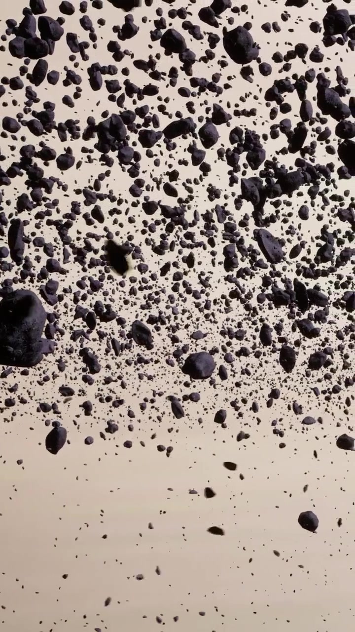 De nombreuses petites roches flottant dans l'air avec un fond uni au loin