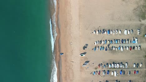 Vista-Aérea-Sobre-Algunos-Barcos-De-Pescadores-Estacionados-En-La-Playa-Con-Vistas-Al-Mediterráneo-En-La-Costa-Del-Maresme-Provincia-De-Barcelona