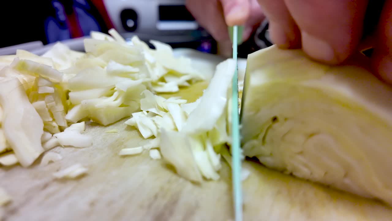 Tagliare a mano il cavolo fresco su un tagliere, preparando cibo sano da cucinare