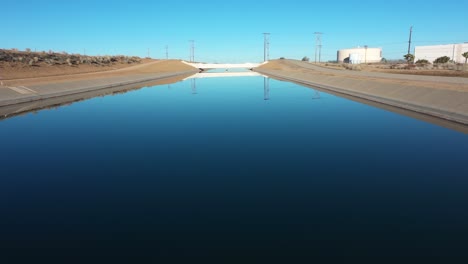 inclinación aérea lenta del carro de un acueducto en hesperia california en un día de pájaro azul en la mañana
