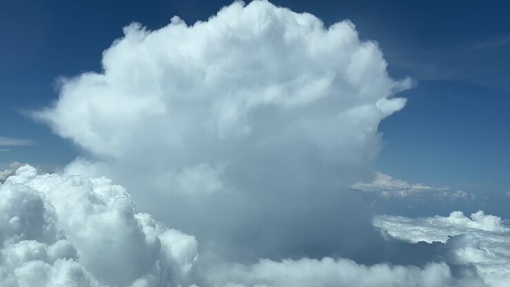 Awesome view from a jet cabin of a storm cloud ahead in a turbulent sky while flying at 12000m high