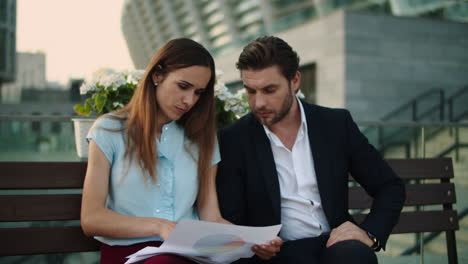 pareja de negocios trabajando con documentos en la ciudad. profesionales sentados en el banco