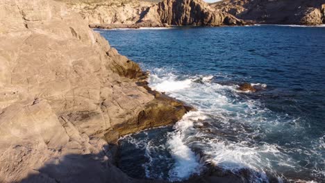 Antena-De-Olas-De-Acantilados-Rompiendo-En-Hermosas-Rocas,-Piscina-Natural,-Adelante,-Día