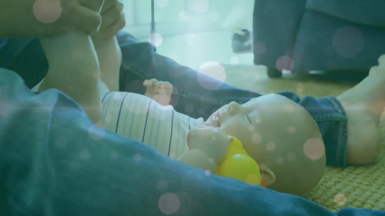 赤ちゃんと遊ぶ白人の母親に重ねられた、浮かぶ点のアニメーション