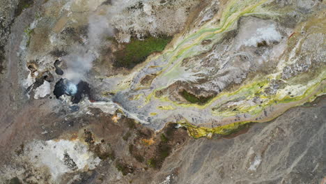 agua hirviendo y vapor en una fuente termal en hveravellir, hermoso oasis en las tierras altas de islandia - toma de arriba hacia abajo