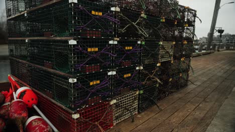 Lobster-fishing-traps-and-bouy-on-pier-coastal-maine-panning-tilting-wide-shot