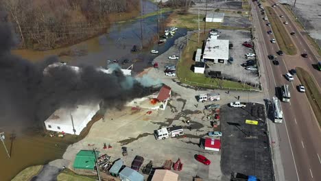 ascending drone view of an active fire with multiple agencies in attendance including local fire and police