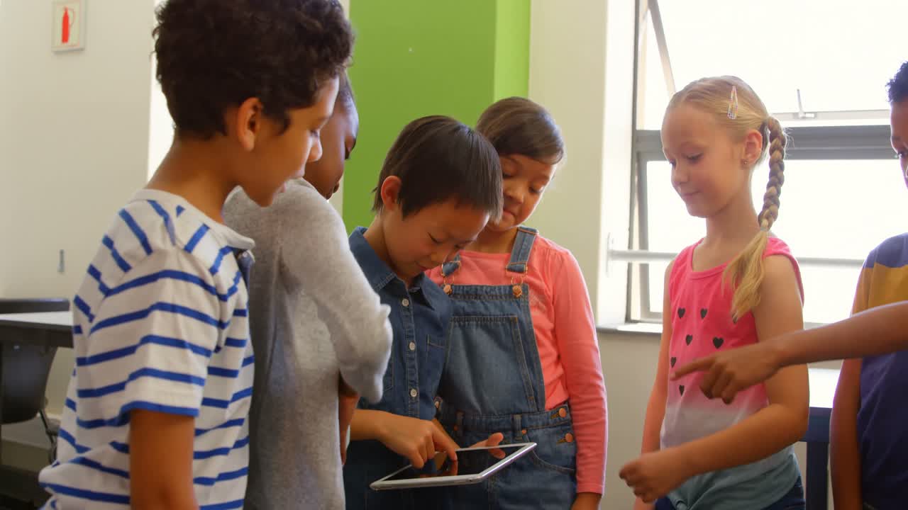 grupo de escolares multiétnicos que usan tableta digital en el aula de la escuela 4k