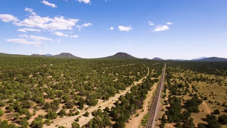 Aerial-flight-North-over-the-empty-Grand-Canyon-Railroad-tracks-leading-to-the-Grand-Canyon,-Arizona