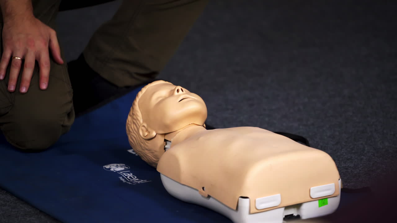 Practical course on a dummy's head. Medic showing medical exercise on a mannequin in the training center. Close-up.