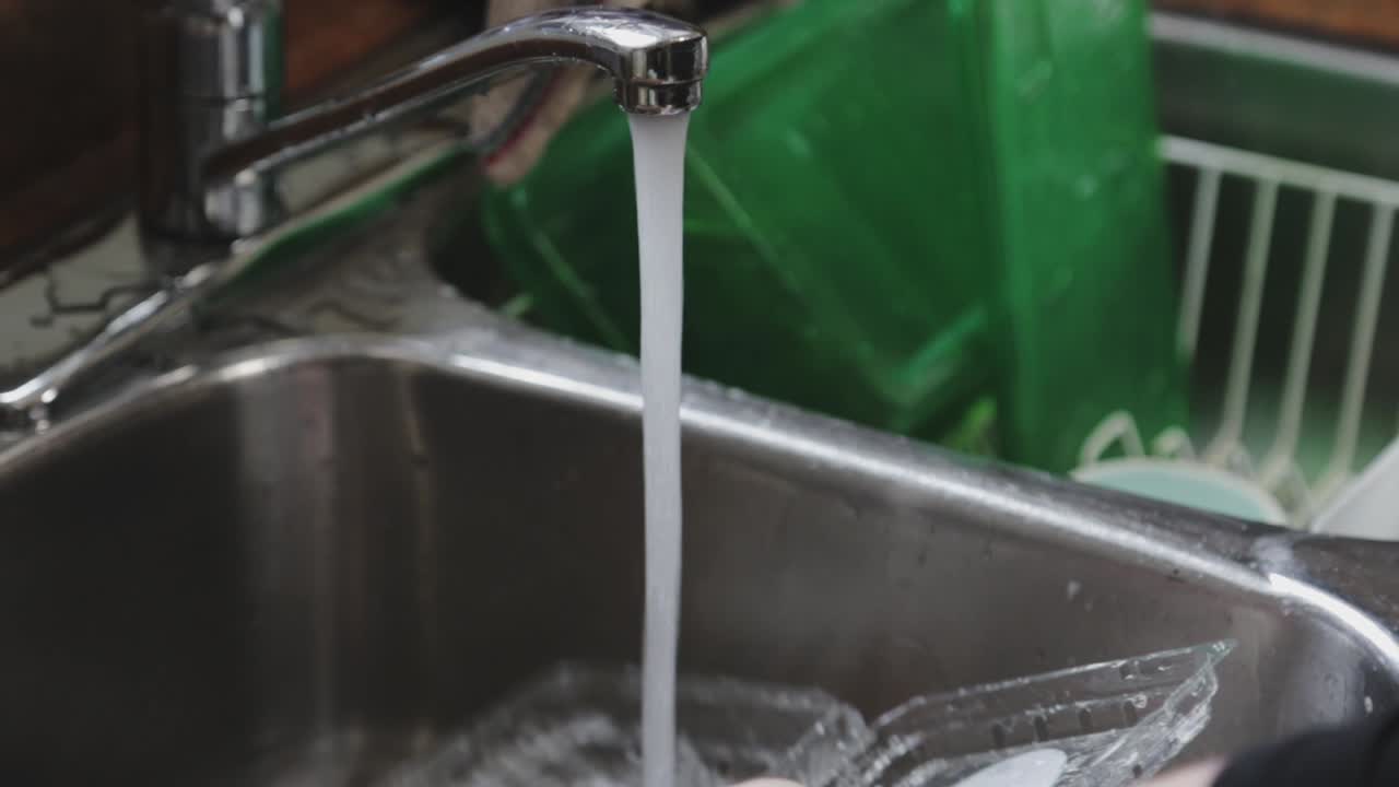 un recipiente sucio se está lavando y enjuagando