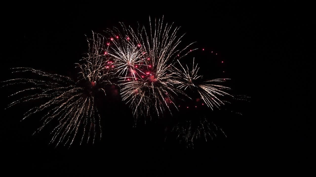 Long time seamless loop of real abstract colourful fireworks festival display at black background sky during national holiday, new year party 2022