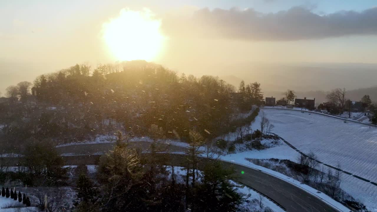 aerial of snow falling at sunrise in blowing rock nc, north carolina