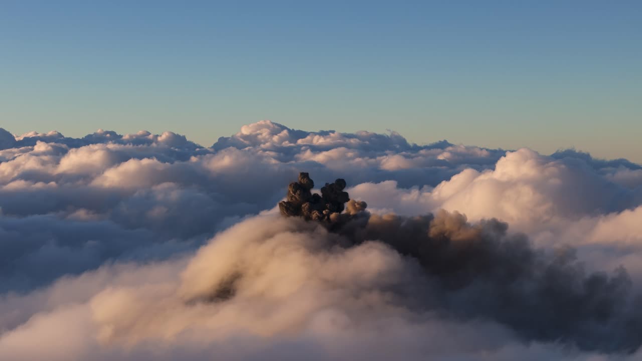 Volcan de Fuego explosive ash plume eruption at dawn, aerial view above the clouds with volcano cone concealed