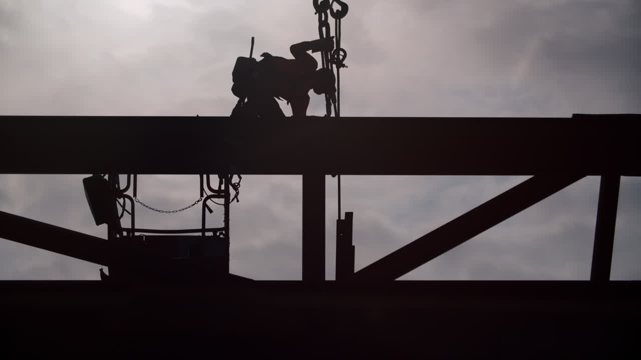 Silhouette of a Worker on a High Structure