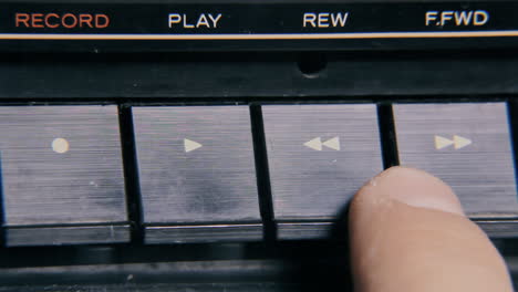 pressing buttons on an old retro vintage cassette tape player: play, fast forward, rewind, stop