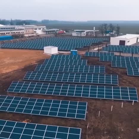 huge station with solar panels. aerial view of solar panels stand in a row in the fields