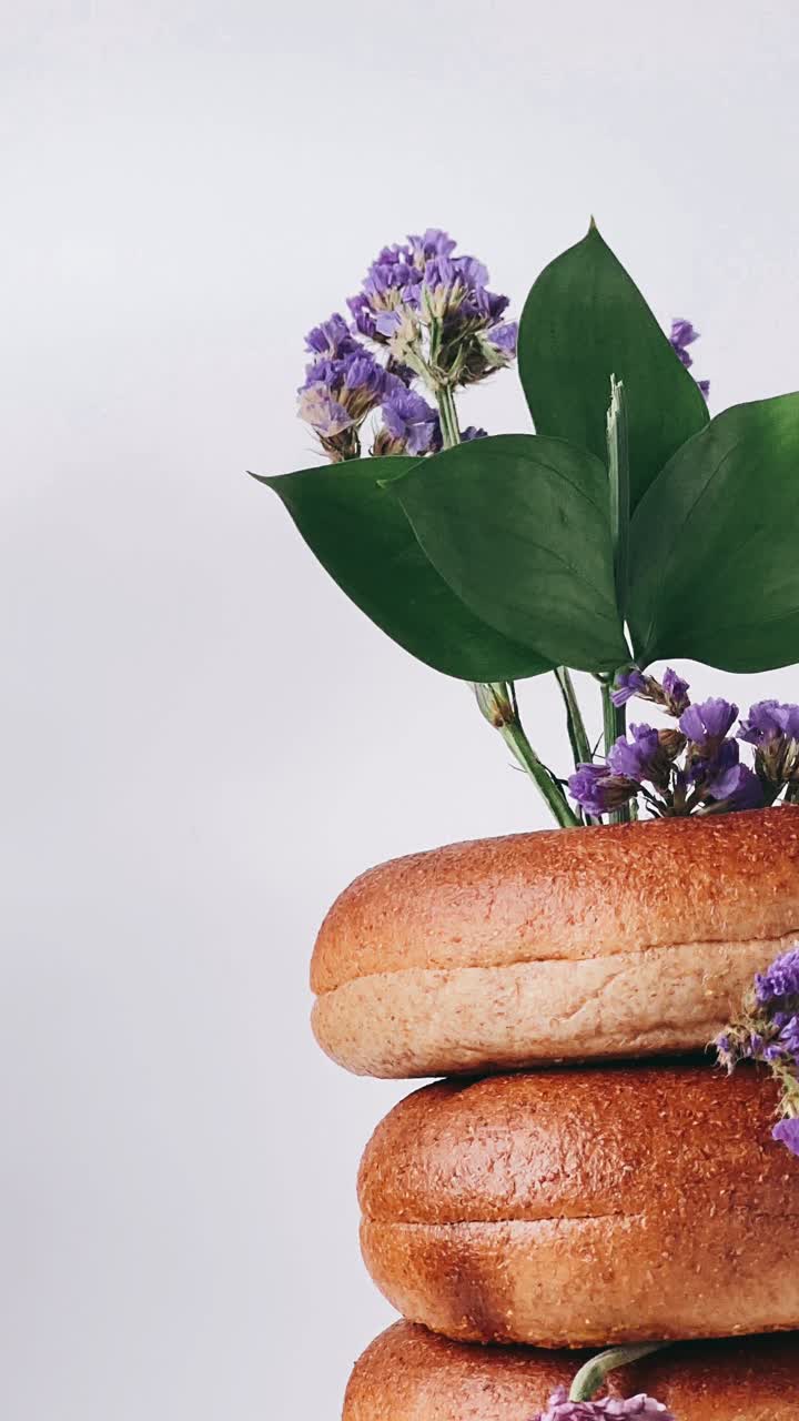 una pila de bagels con flores púrpuras