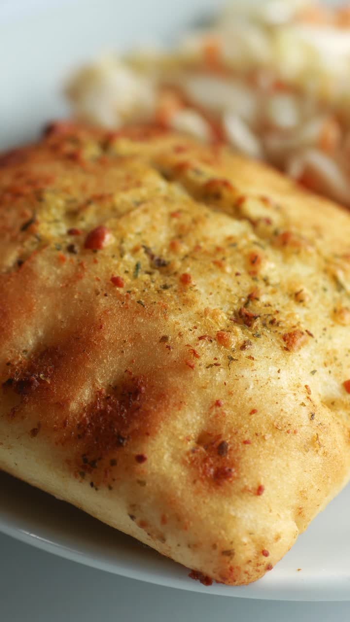 Primo piano di focaccia dorata con coleslaw su un piatto.