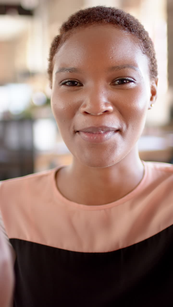 Vertical video of portrait of african american casual businesswoman having video call, slow motion