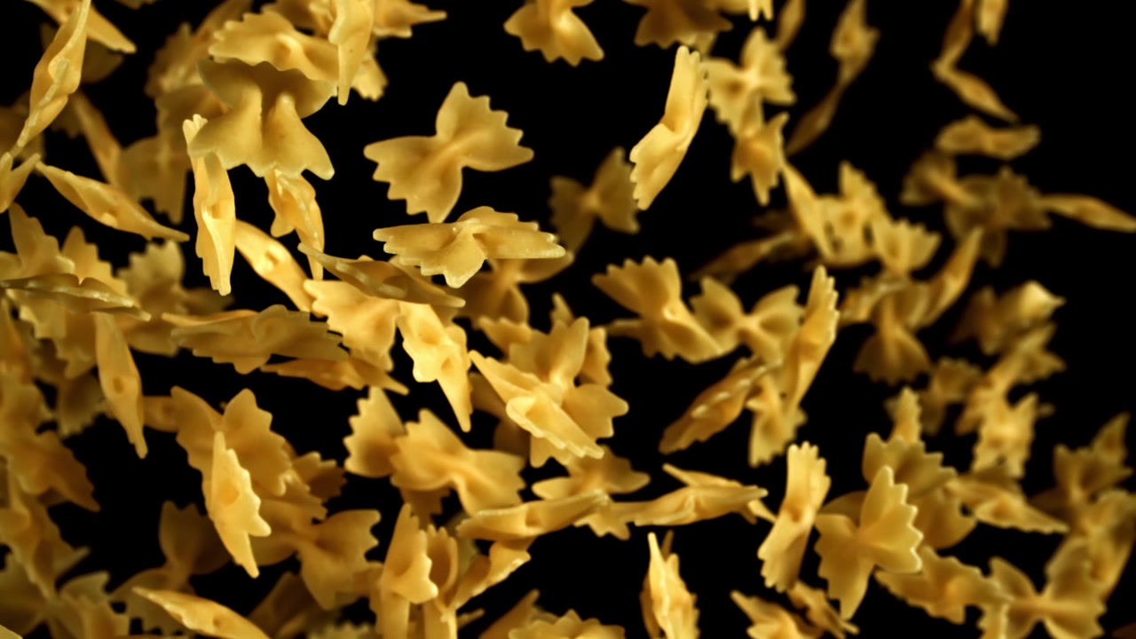 Pasta farfalle che cade al rallentatore su sfondo nero