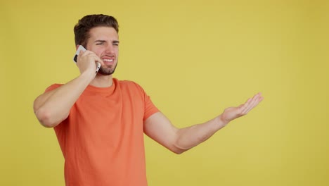 confused man talking on phone and gesturing on yellow background