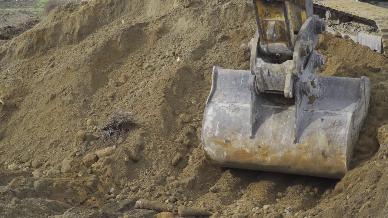 primer plano de la maquinaria que retira arenas contaminadas de una playa mientras limpia los desechos extractivos