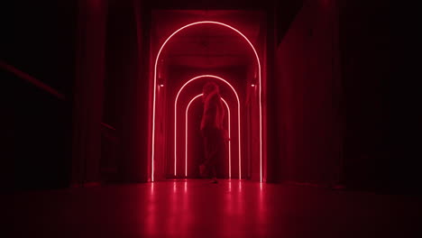 person walking through a neon red lit corridor