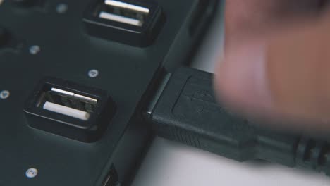 man connects usb cable to modern hub on white background