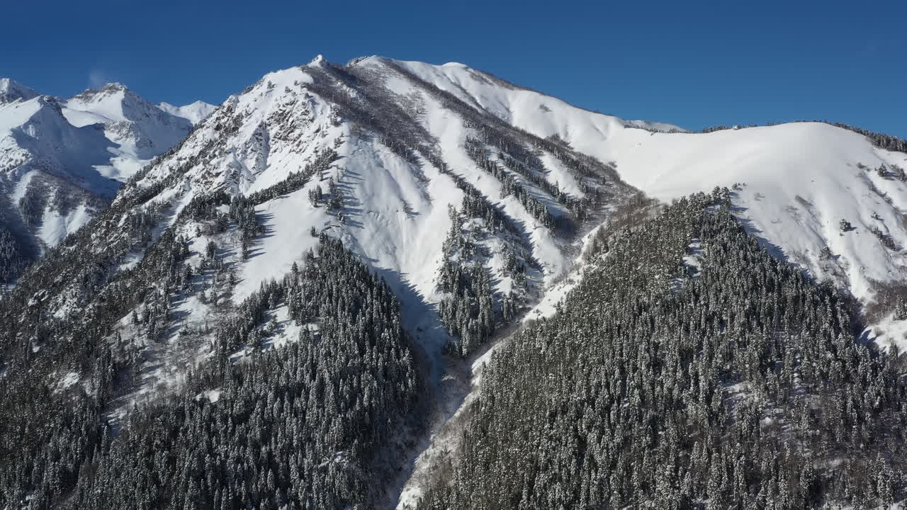 Volo aereo tra le nuvole di montagna sopra splendide vette innevate e ghiacciai.