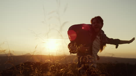 man spinning woman on shoulders at sunset