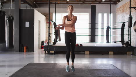 video de una mujer caucásica en forma saltando en la cuerda de salto en el gimnasio