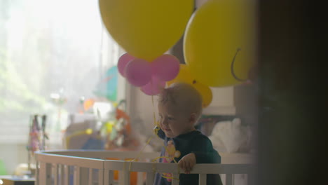 Niña-Jugando-Con-Globos-En-La-Cuna