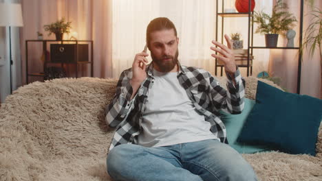 молодой человек беспокоится дома телефон на коленях громкий звонок ссора разочарованный разговор горячий спор вибрация