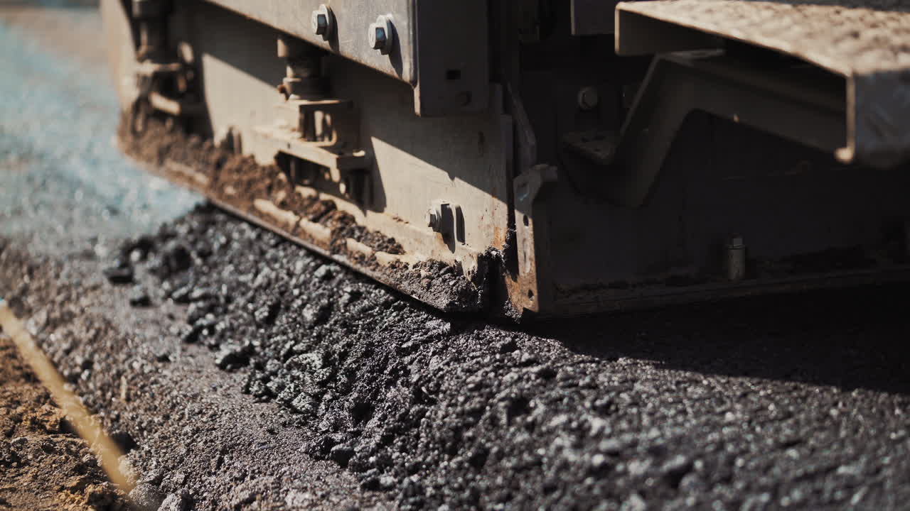 Works road roller with asphalt. Repair asphalt covering with asphalting paver machine