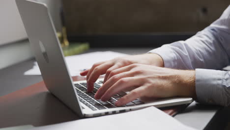 Close-up-detail-of-businessman's-hands-using-laptop-computer