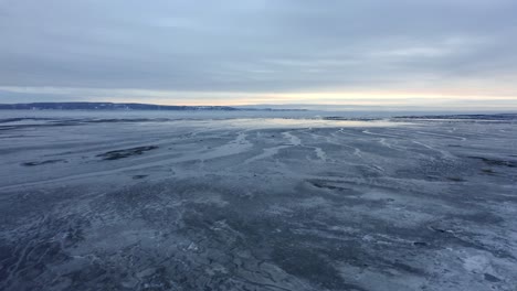 drone flying over the frozen shore of the river in charlevoix
