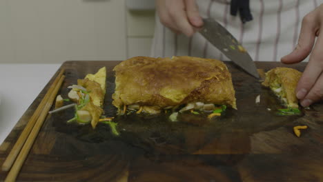 cutting abalone and egg asian dish and placing it into the plate for decoration